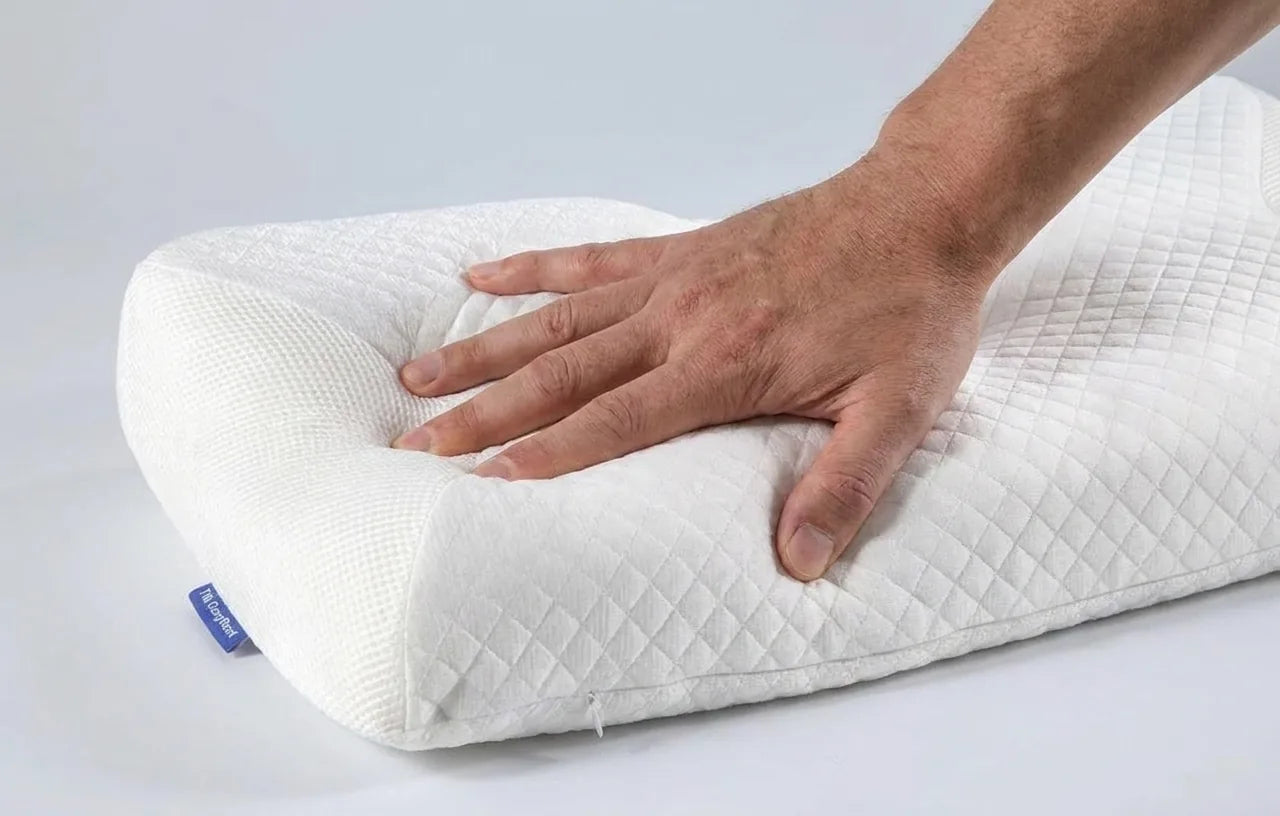 Hand pressing the CozyRest pillow showing 5.0 lb/ft³ memory foam density